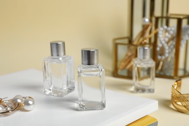 Photo of Bottle of perfumes and stylish earrings on magazines