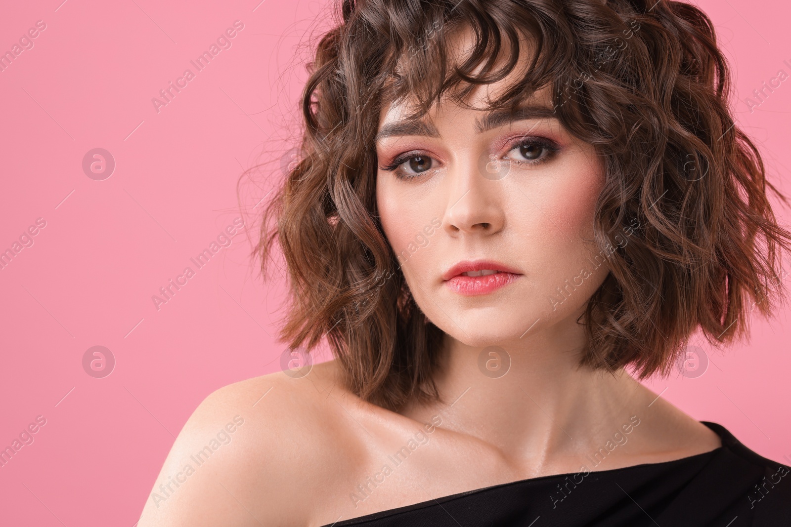Photo of Beautiful young woman with wavy hairstyle on pink background. Space for text