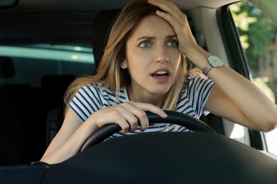 Photo of Stressed woman in driver's seat of modern car, view through windshield