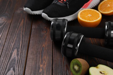 Weight loss concept. Sneakers, dumbbells and products on wooden table, space for text