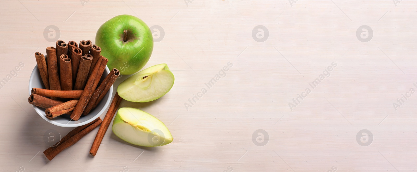 Image of Fresh apples and cinnamon sticks on table, space for text. Banner design