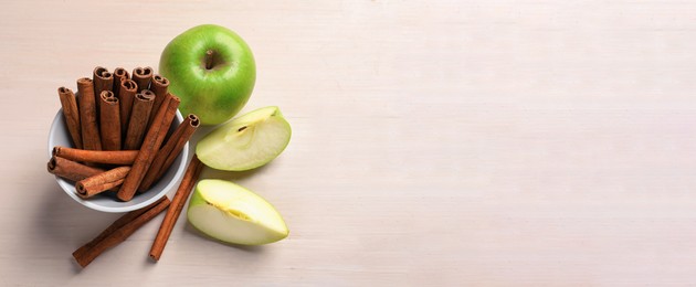 Fresh apples and cinnamon sticks on table, space for text. Banner design