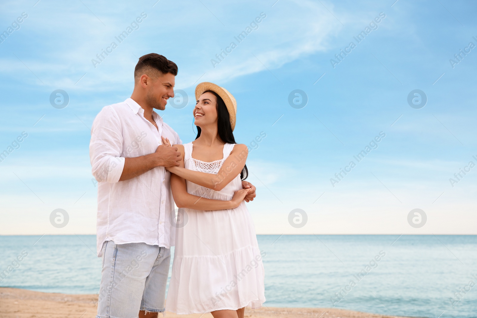 Photo of Lovely couple dancing on beach near sea. Space for text