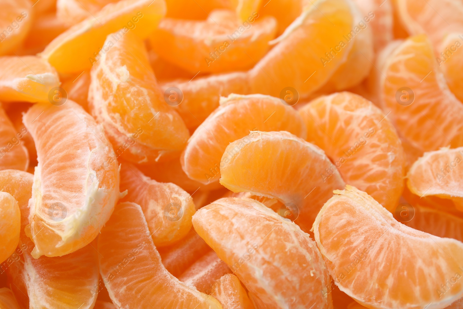 Photo of Segments of tasty tangerines as background, closeup