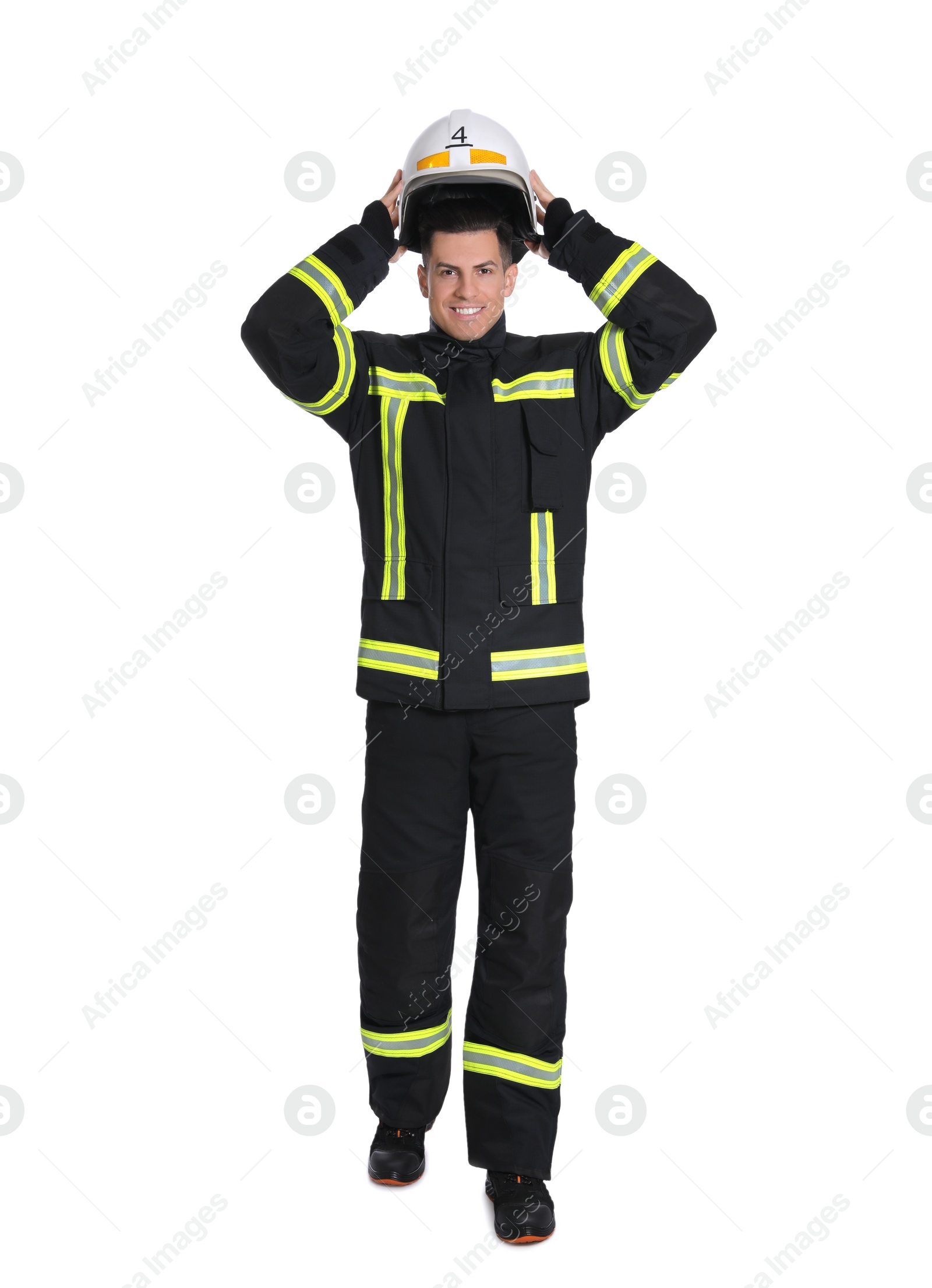 Photo of Full length portrait of firefighter in uniform wearing helmet on white background