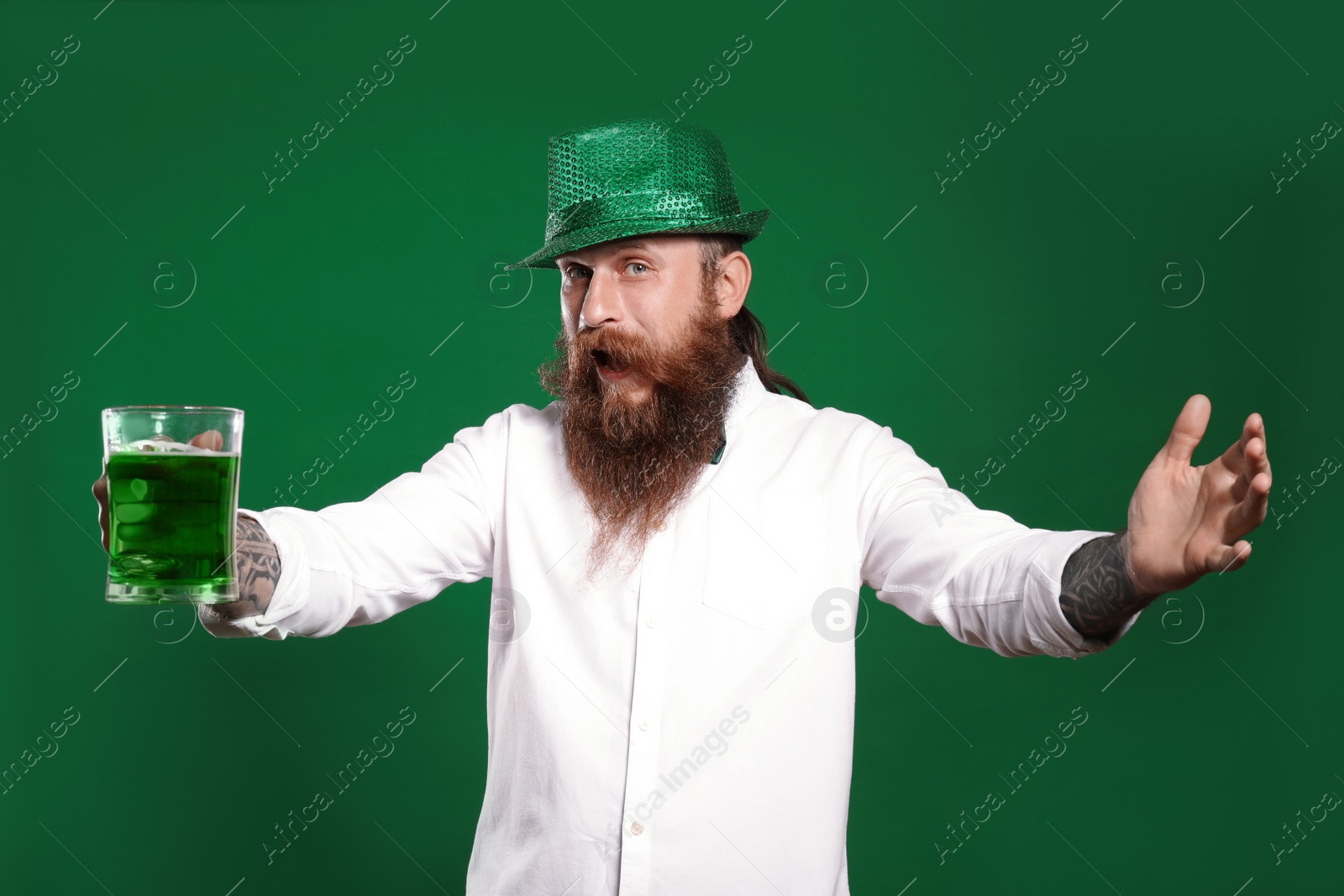 Photo of Bearded man with green beer on color background. St. Patrick's Day celebration