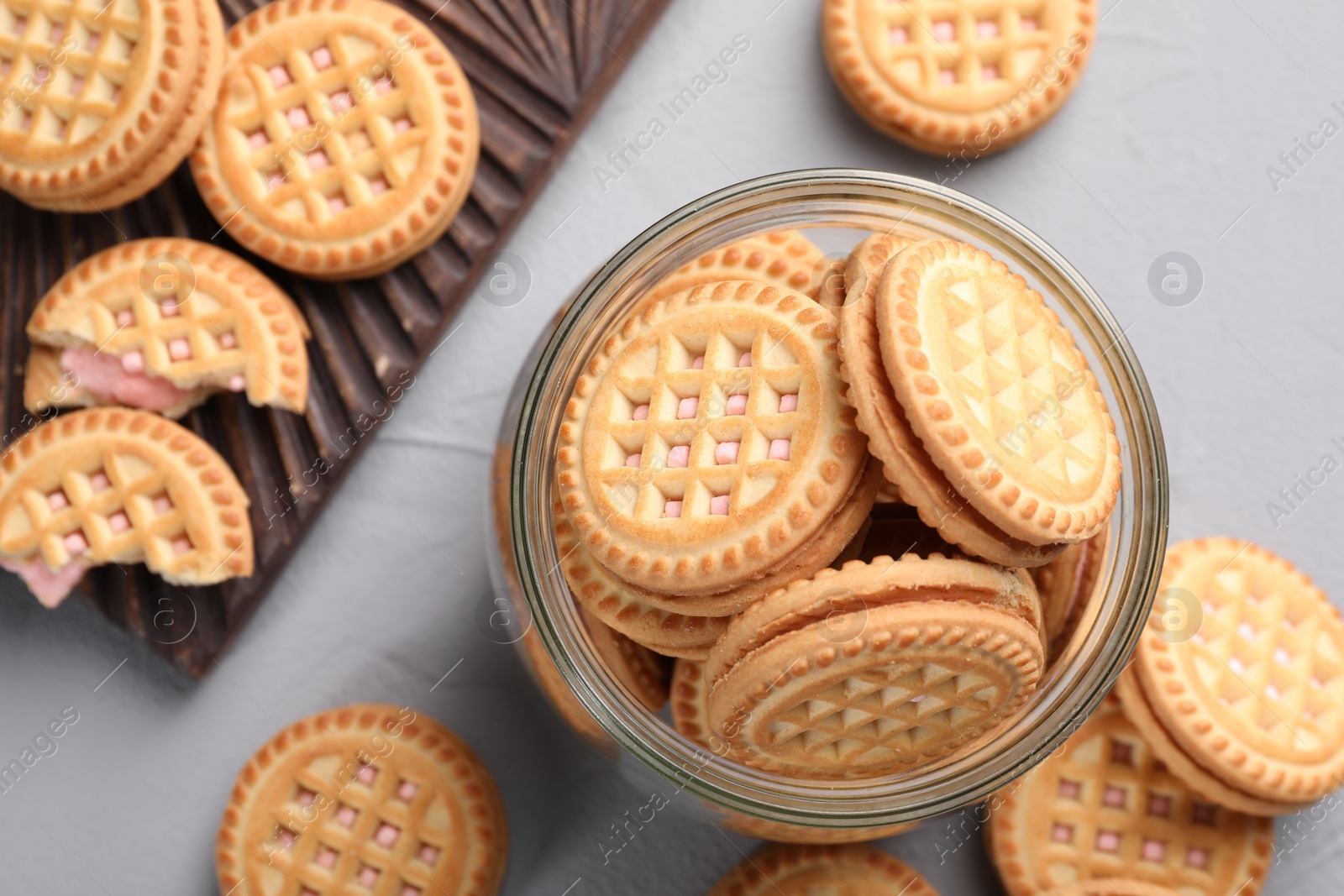 Photo of Tasty sandwich cookies with cream on light grey table, flat lay