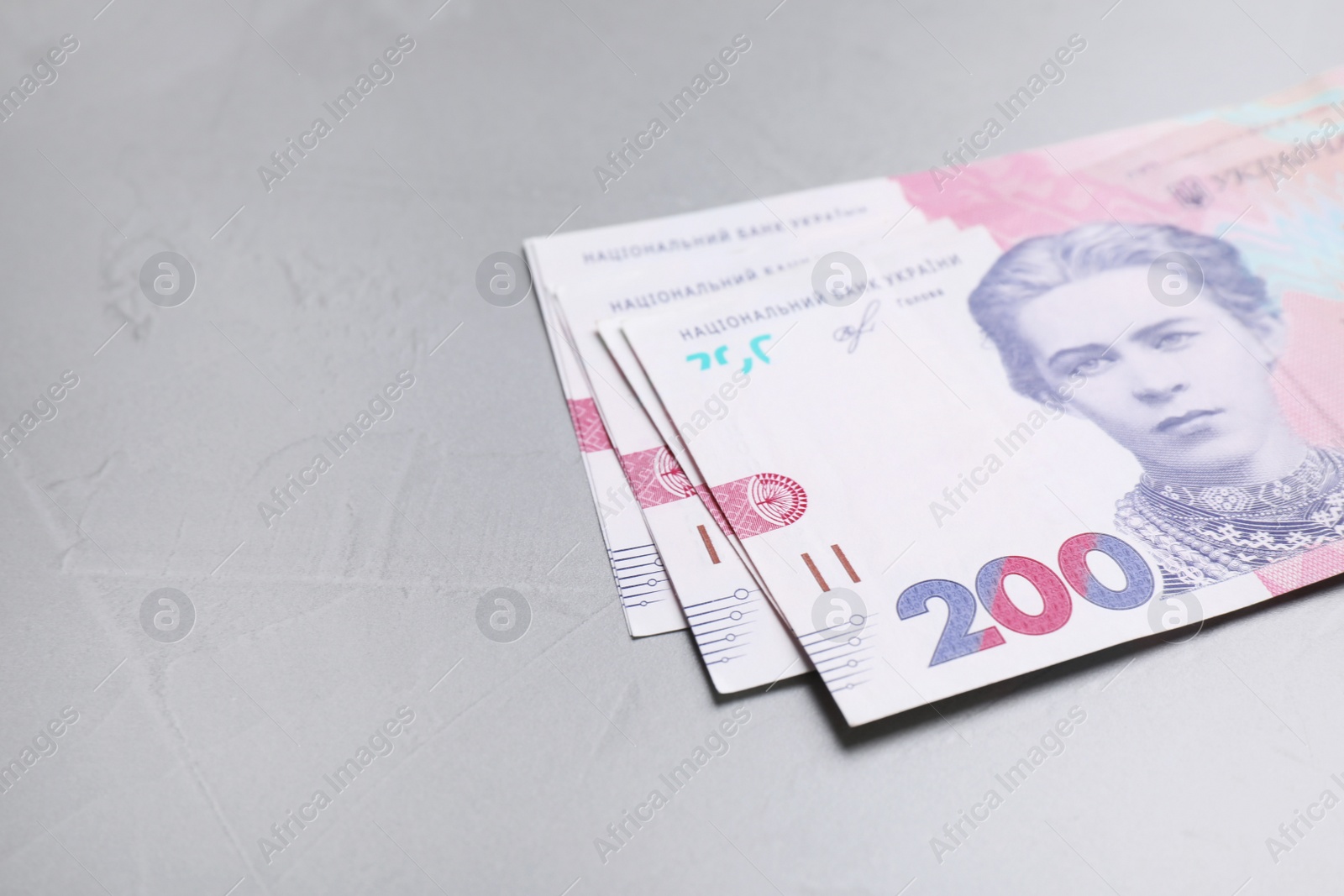 Photo of Ukrainian money on grey background, closeup. Space for text