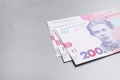 Photo of Ukrainian money on grey background, closeup. Space for text