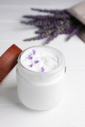 Photo of Jar of face cream and beautiful lavender on white wooden table