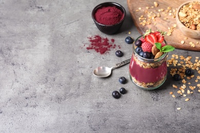 Delicious acai dessert with granola and berries served on grey table. Space for text