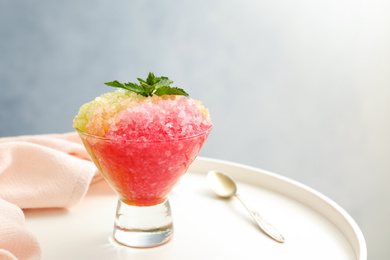 Photo of Shaving ice in glass dessert bowl on white table, closeup