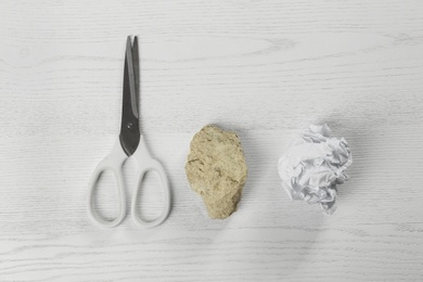 Photo of Flat lay composition with rock, paper and scissors on white wooden background