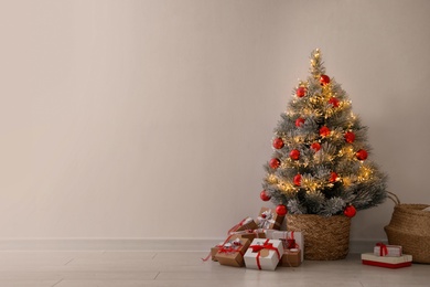 Photo of Pile of gift boxes near beautiful Christmas tree indoors, space for text. Advent calendar