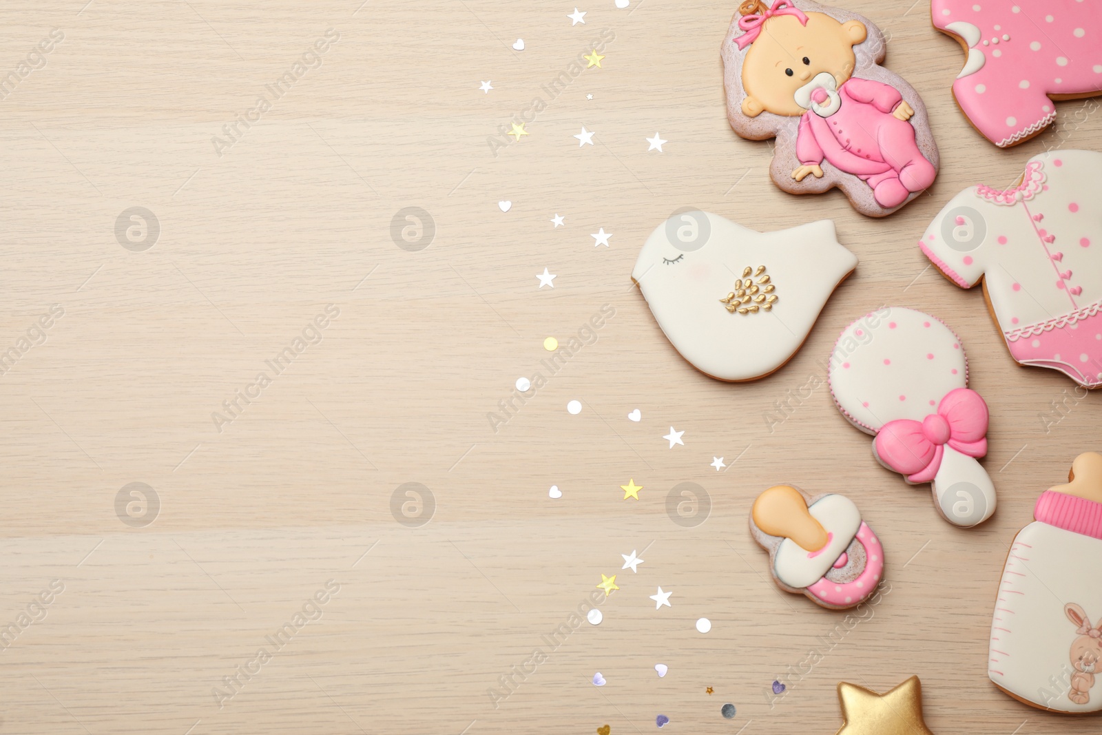 Photo of Set of baby shower cookies on wooden table, flat lay. Space for text