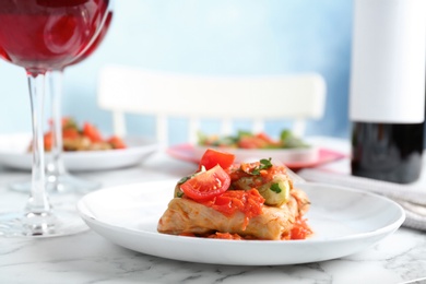 Photo of Plate with stuffed cabbage leaves in tomato sauce on table