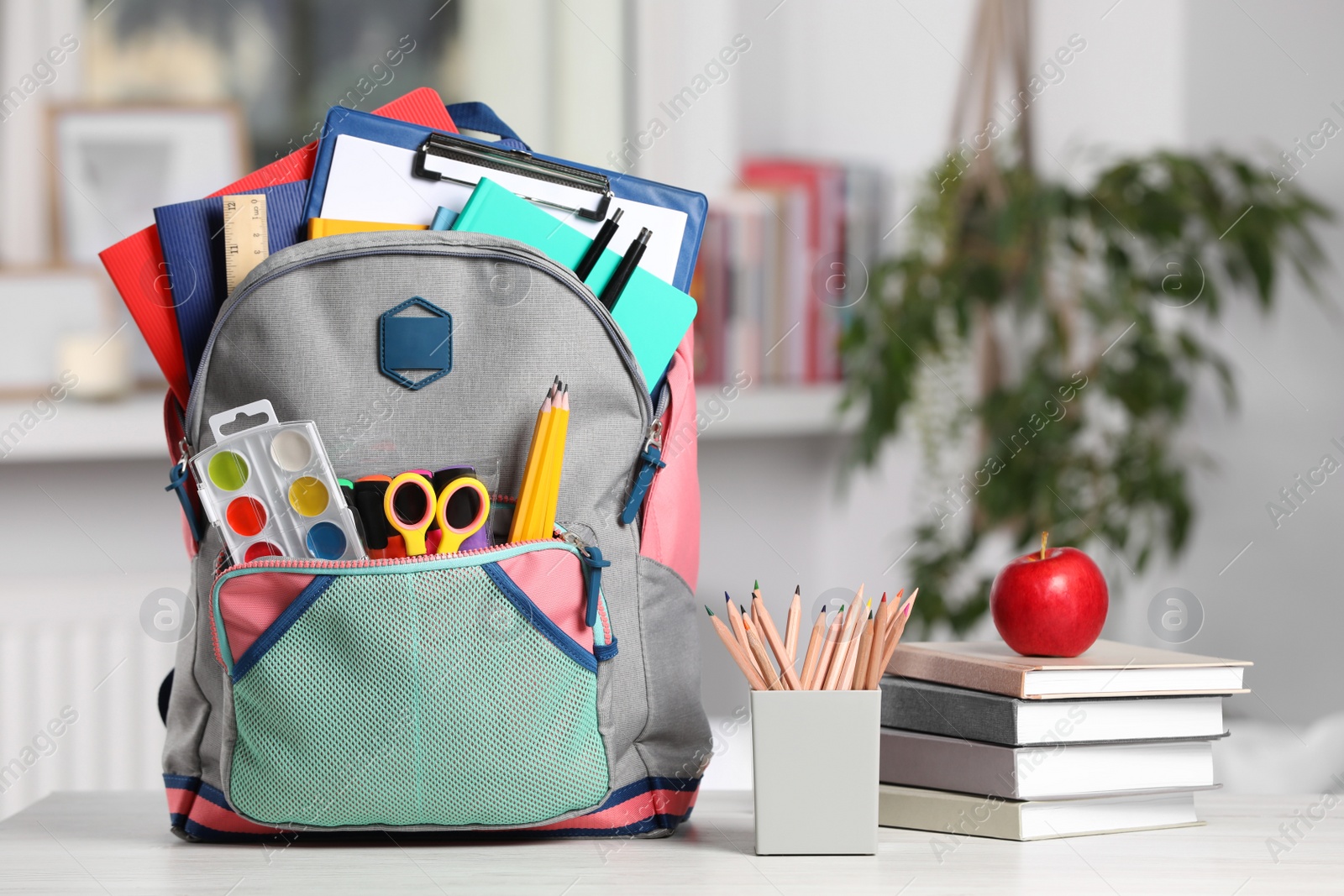 Photo of Backpack and different school stationery on white table indoors