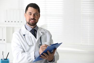 Portrait of male doctor in white coat at workplace