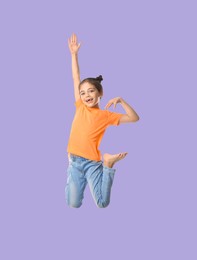 Happy cute girl jumping on light violet background
