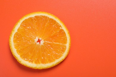 Slice of juicy orange on terracotta background, top view. Space for text