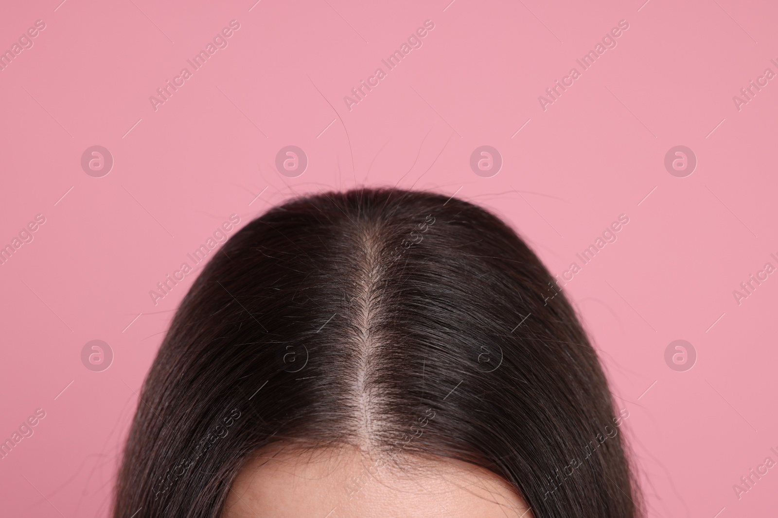 Photo of Woman with healthy dark hair on pink background, closeup