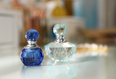 Bottles of perfumes on dressing table in stylish room interior