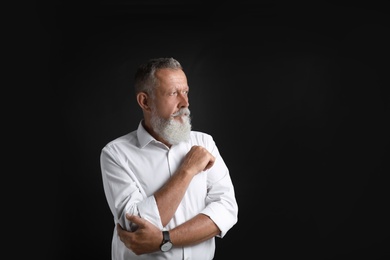 Portrait of handsome senior man on black background