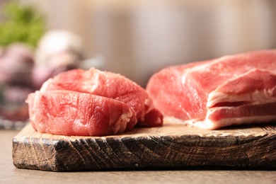 Fresh raw meat on wooden table in kitchen, closeup