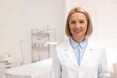 Photo of Portrait of happy dermatologist in modern clinic, space for text