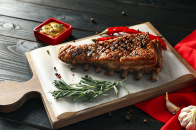 Photo of Delicious roasted ribs served on wooden table