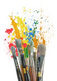 Different brushes and paint splatters on white background