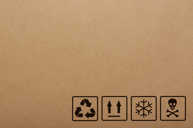 Cardboard box with packaging symbols as background, closeup