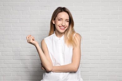 Portrait of young woman with beautiful face near white brick wall