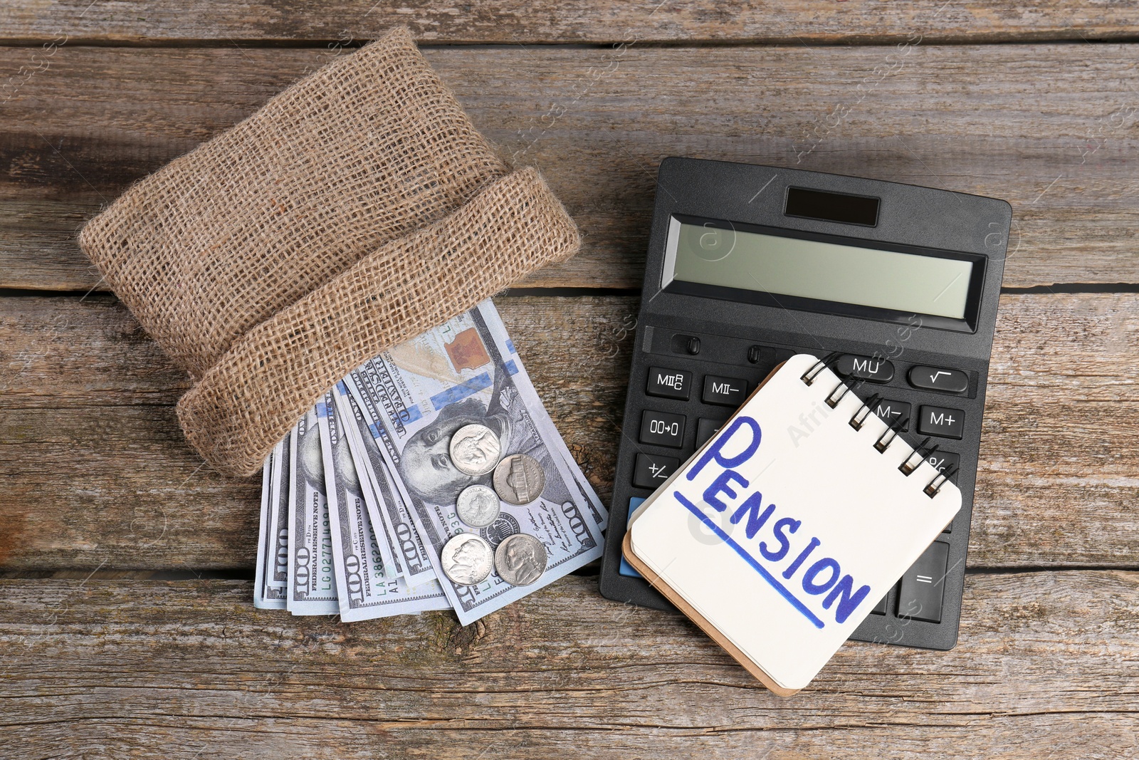 Photo of Bag with money, notebook with word Pension and calculator on wooden table, flat lay. Retirement concept