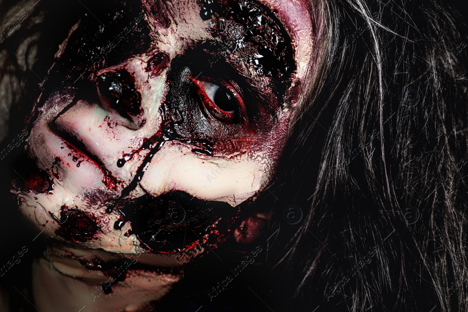 Photo of Scary zombie with bloody face, closeup. Halloween monster