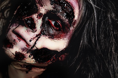 Photo of Scary zombie with bloody face, closeup. Halloween monster