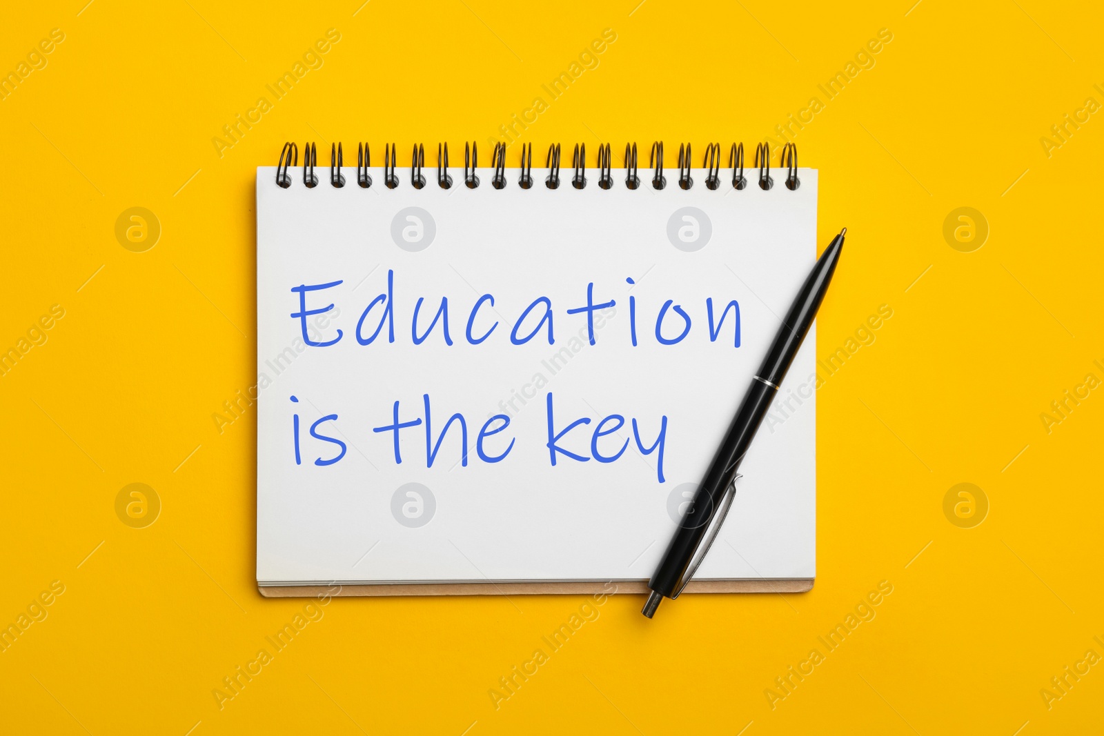 Image of Office stationery with text Education is the key on yellow background, top view. Adult learning