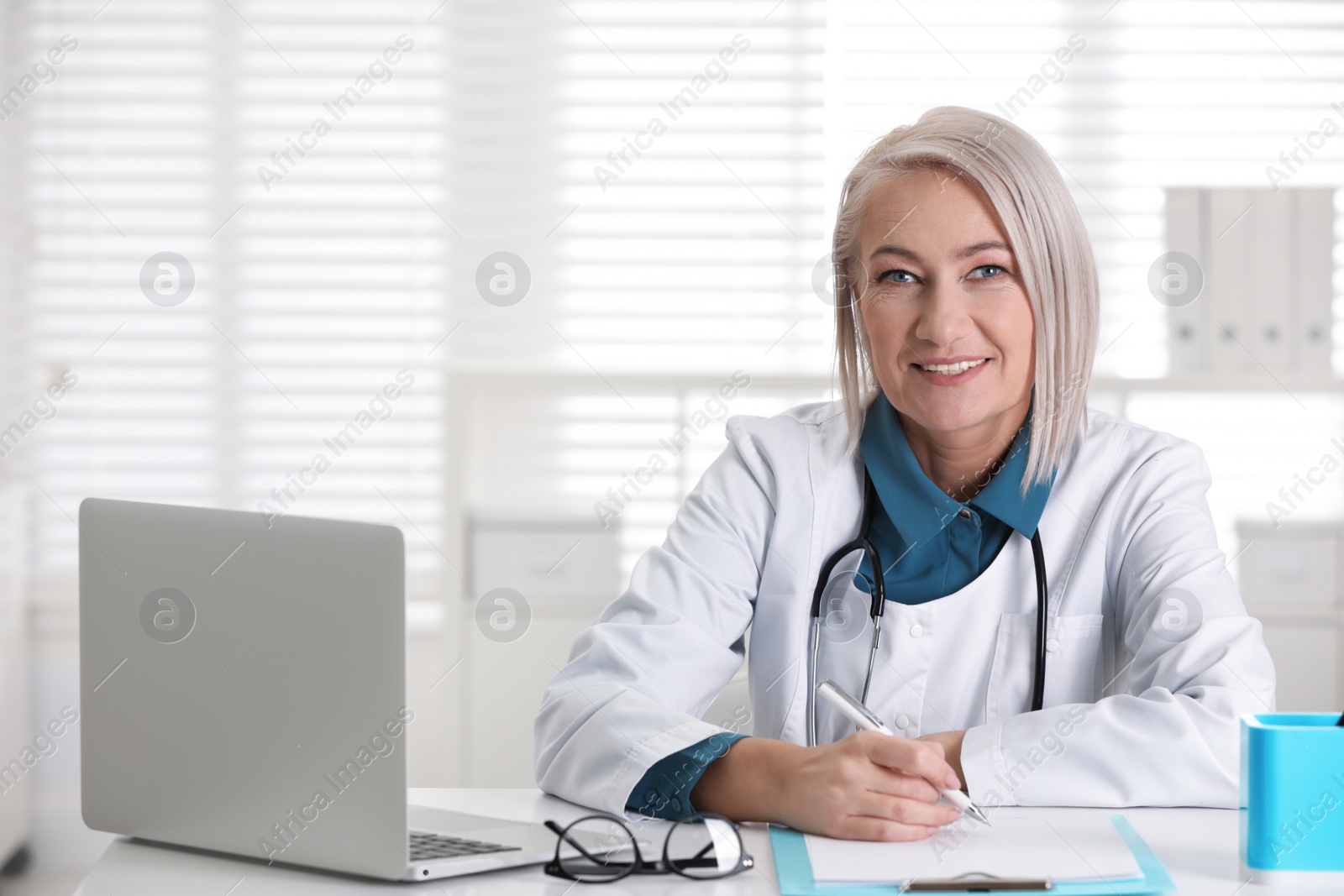 Photo of Portrait of mature female doctor in white coat at workplace