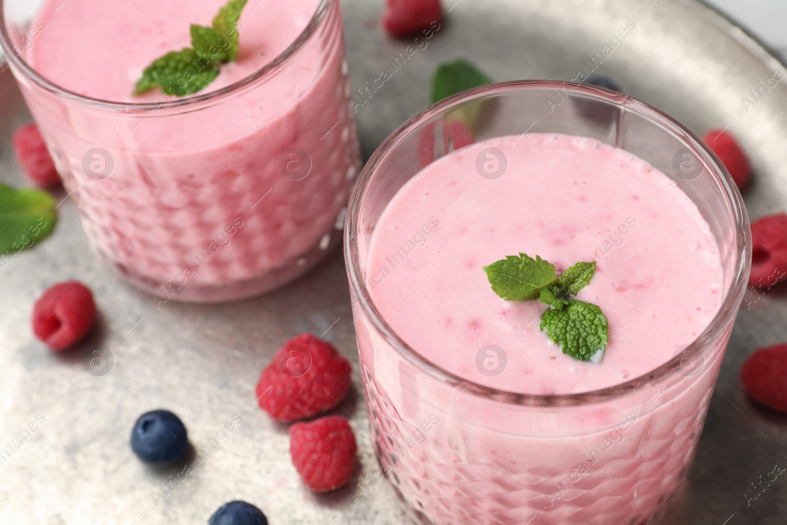 Photo of Delicious smoothie with raspberries in glasses, closeup