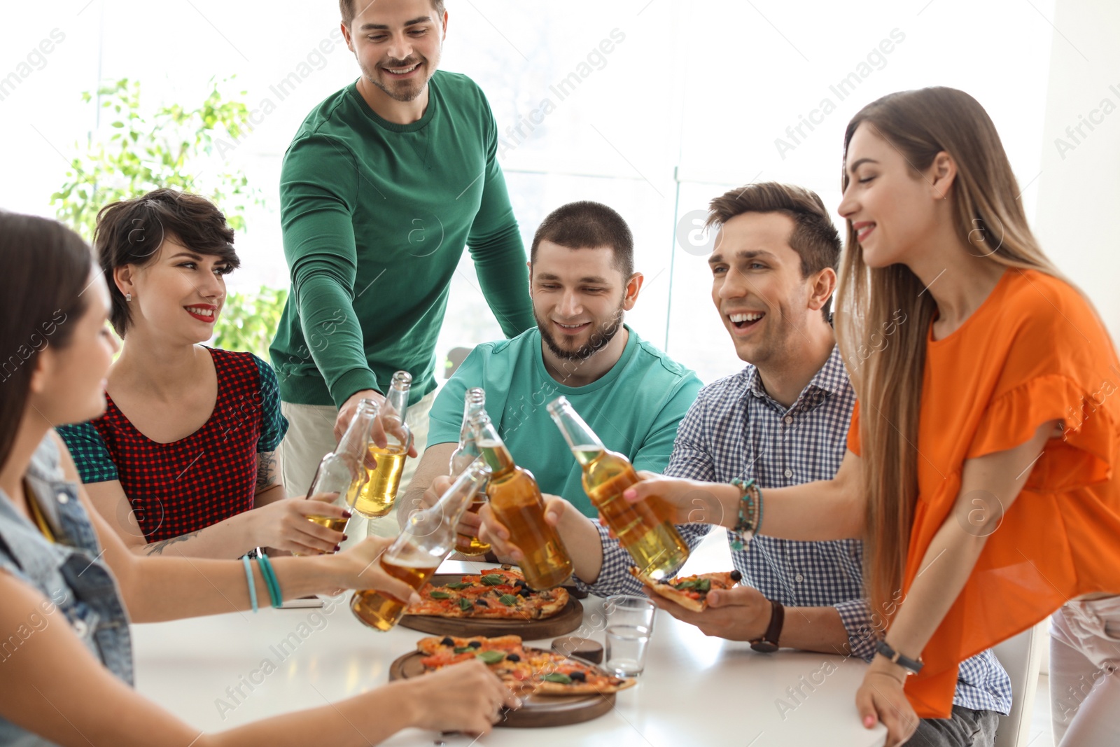 Photo of Young people having fun party with delicious pizza indoors