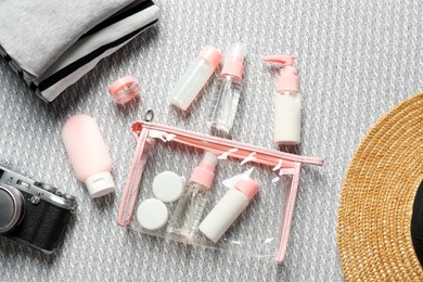 Photo of Flat lay composition with cosmetic travel kit on sofa