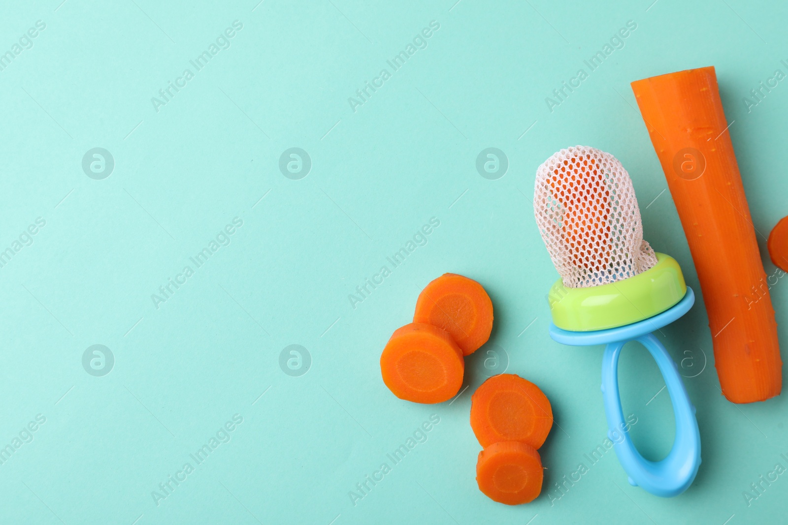 Photo of Nibbler with boiled carrot on turquoise background, flat lay. Space for text