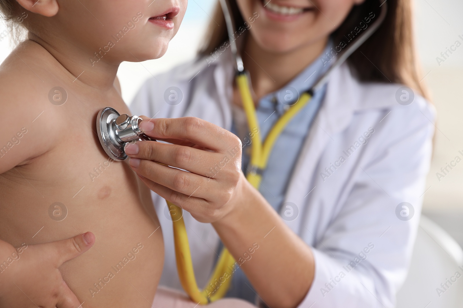 Photo of Pediatrician examining baby with stethoscope in clinic, closeup