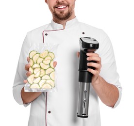 Photo of Smiling chef holding sous vide cooker and zucchini in vacuum pack on white background, closeup