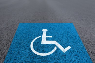 Image of Wheelchair symbol on asphalt road. Disabled parking permit