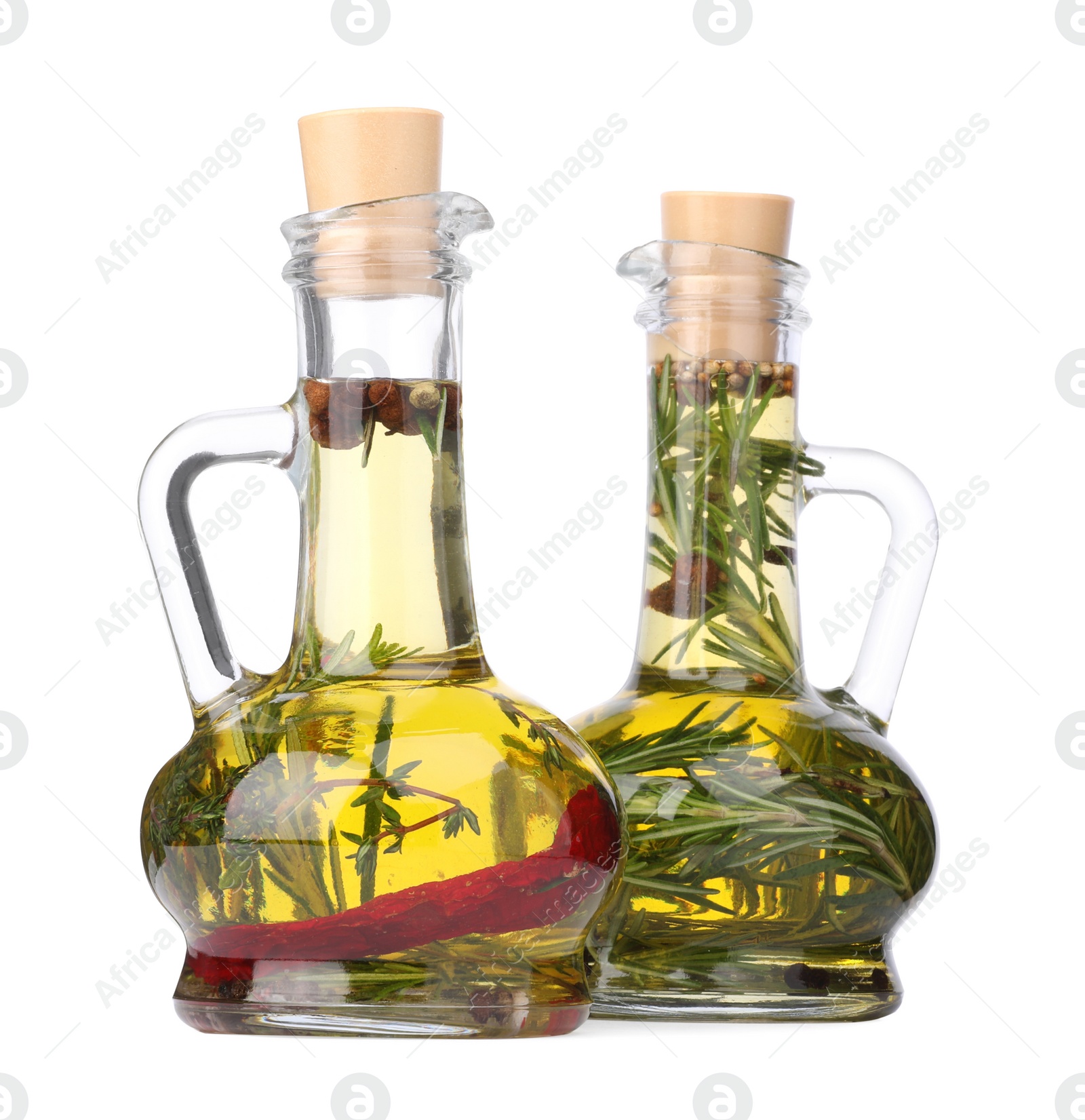 Photo of Glass jugs of cooking oils with spices and herbs on white background