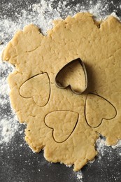 Making shortcrust pastry. Raw dough and cookie cutter on grey table, top view