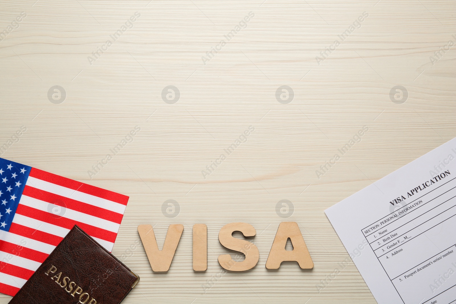 Photo of Flat lay composition with American flag, visa application form and passport on white wooden table, space for text