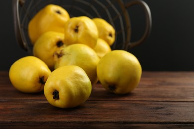 Photo of Delicious ripe quinces on wooden table, closeup. Space for text