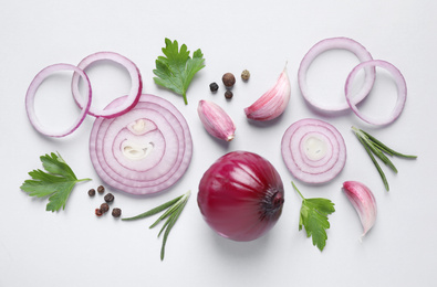 Flat lay composition with sliced onion and spices on light background